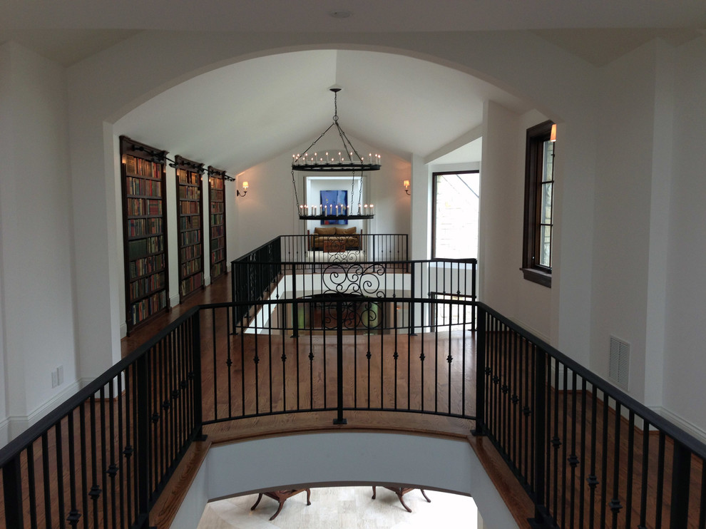 Expansive traditional hallway in Cincinnati with white walls and medium hardwood floors.