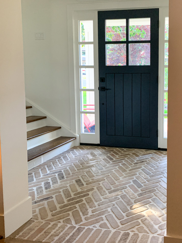 Ejemplo de puerta principal de estilo de casa de campo grande con paredes blancas, suelo de ladrillo, puerta simple, puerta azul, suelo beige, todos los diseños de techos y todos los tratamientos de pared