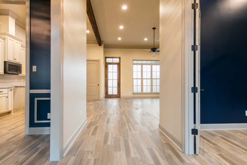 Photo of a mid-sized transitional foyer in New Orleans with a single front door, beige walls, ceramic floors, a dark wood front door and beige floor.