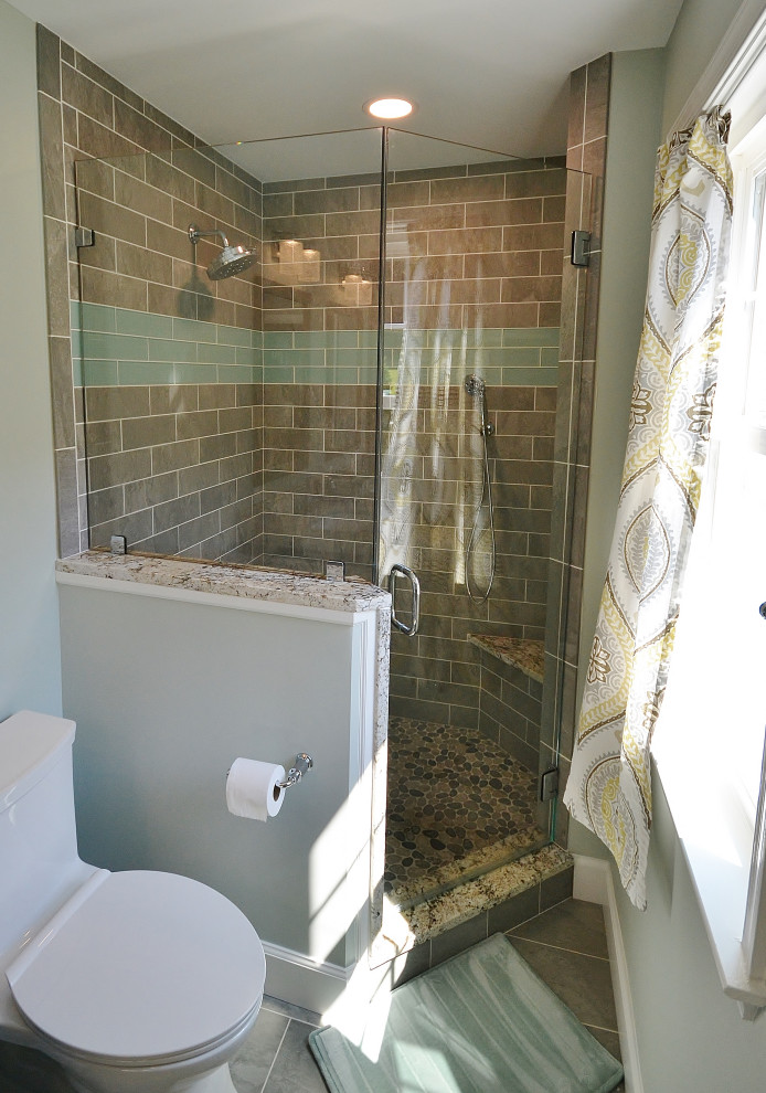 Photo of a large transitional master bathroom in Philadelphia with raised-panel cabinets, brown cabinets, a corner shower, a one-piece toilet, beige tile, ceramic tile, beige walls, laminate floors, an undermount sink, granite benchtops, black floor, a hinged shower door and multi-coloured benchtops.
