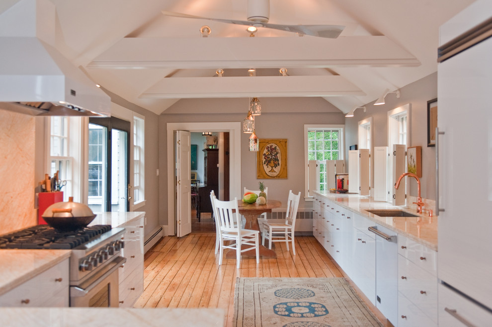 Inspiration for a large galley light wood floor enclosed kitchen remodel in Boston with an undermount sink, flat-panel cabinets, white cabinets, marble countertops, stone slab backsplash, white appliances, gray walls and no island