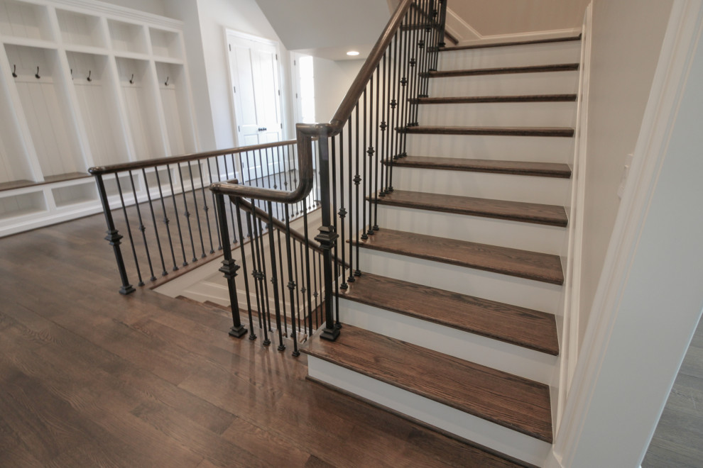 Large elegant wooden floating metal railing staircase photo in DC Metro with painted risers