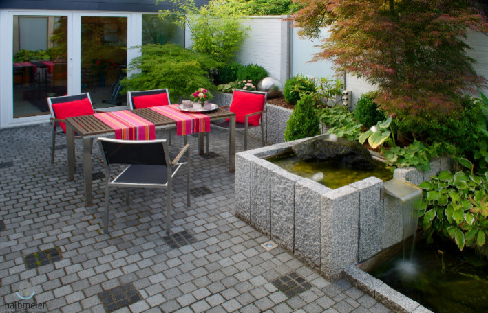 Idee per un piccolo patio o portico design in cortile con pavimentazioni in pietra naturale