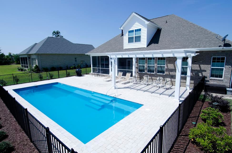 Inspiration for a large traditional backyard rectangular pool in Wilmington with a pool house and concrete pavers.