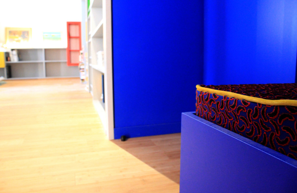 Modelo de distribuidor minimalista pequeño con paredes azules, suelo de bambú, puerta simple, puerta azul y suelo beige