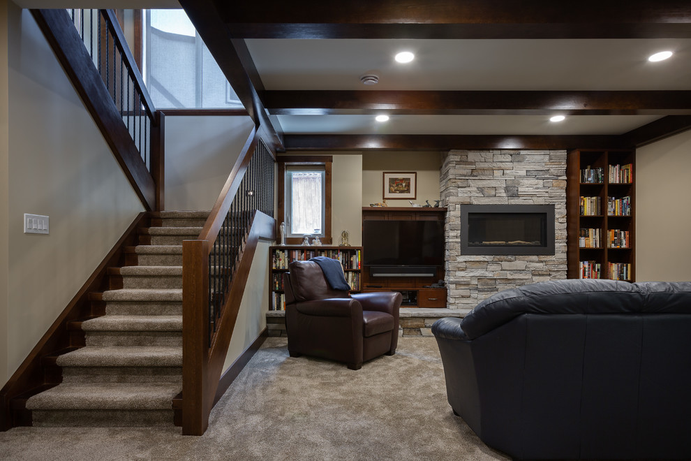 This is an example of a large transitional look-out basement in Other with beige walls, carpet, a standard fireplace, a stone fireplace surround and beige floor.
