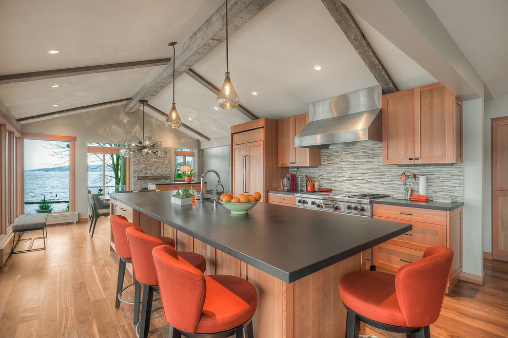 Mid-sized transitional galley open plan kitchen in Seattle with shaker cabinets, light wood cabinets, grey splashback, with island, grey benchtop, an undermount sink, quartz benchtops, mosaic tile splashback, stainless steel appliances, medium hardwood floors, brown floor and exposed beam.