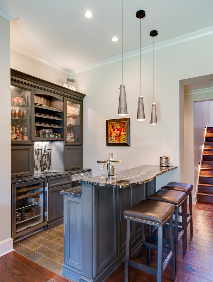 Inspiration for a mid-sized transitional seated home bar in Other with an undermount sink, recessed-panel cabinets, grey cabinets, grey splashback, mosaic tile splashback, medium hardwood floors, marble benchtops and brown floor.
