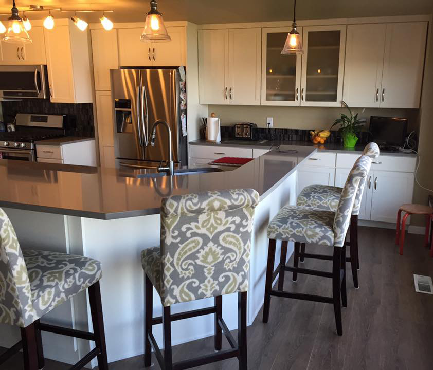 Open concept kitchen - mid-sized transitional l-shaped open concept kitchen idea in Seattle with an undermount sink, shaker cabinets, white cabinets, quartzite countertops, metallic backsplash, glass tile backsplash, stainless steel appliances and an island