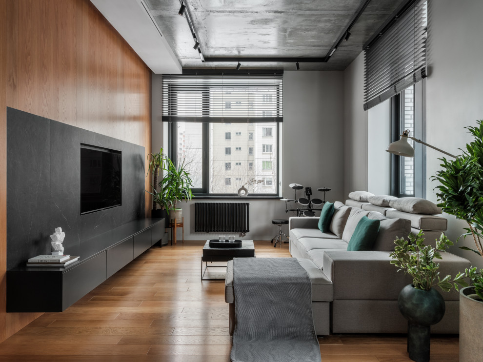 Idee per un soggiorno design di medie dimensioni con sala della musica, pareti beige, pavimento in legno massello medio, TV a parete, pavimento marrone e pannellatura