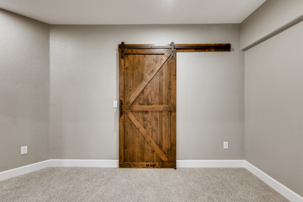 Medium sized country fully buried basement in Denver with a home bar, grey walls, carpet, white floors and wallpapered walls.