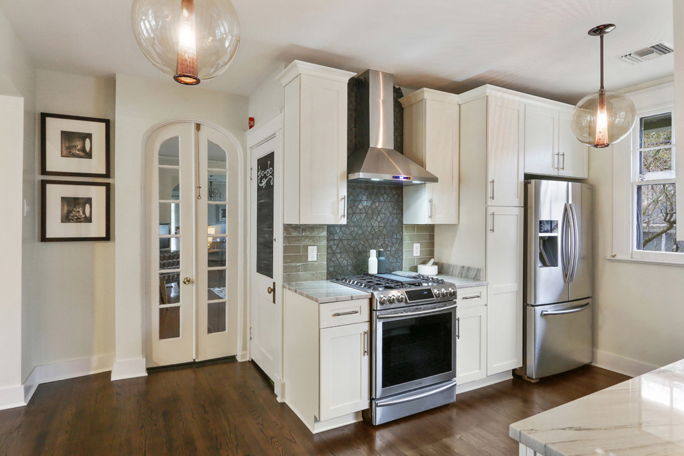This is an example of a small transitional eat-in kitchen in New Orleans with a farmhouse sink, shaker cabinets, white cabinets, marble benchtops, green splashback, glass tile splashback, stainless steel appliances, dark hardwood floors and no island.