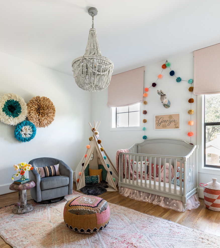 Example of a transitional medium tone wood floor and brown floor nursery design in Houston with white walls