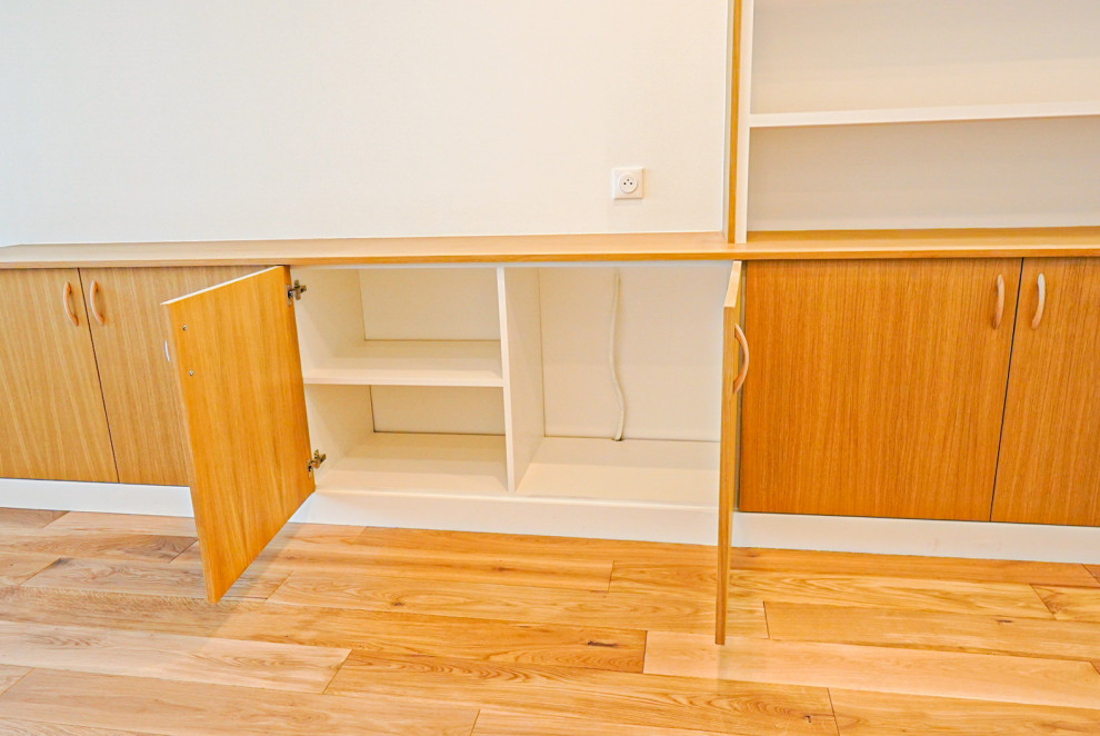 Diseño de salón abierto y blanco y madera moderno pequeño con paredes blancas, suelo de madera clara, pared multimedia y suelo marrón