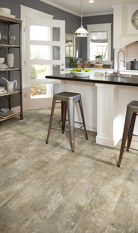 Mid-sized mountain style single-wall light wood floor and beige floor eat-in kitchen photo in DC Metro with a farmhouse sink, shaker cabinets, white cabinets, solid surface countertops, white backsplash, subway tile backsplash, stainless steel appliances and an island