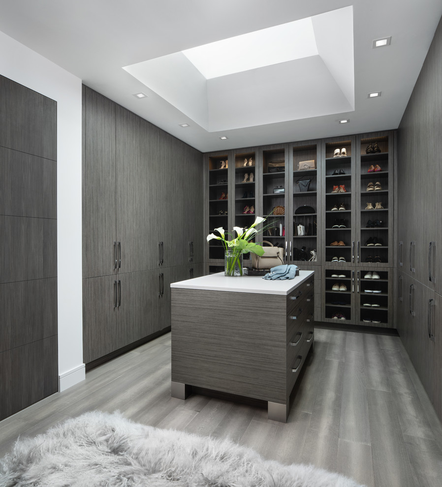 Inspiration for a contemporary dressing room in Detroit with flat-panel cabinets, dark wood cabinets and brown floor.