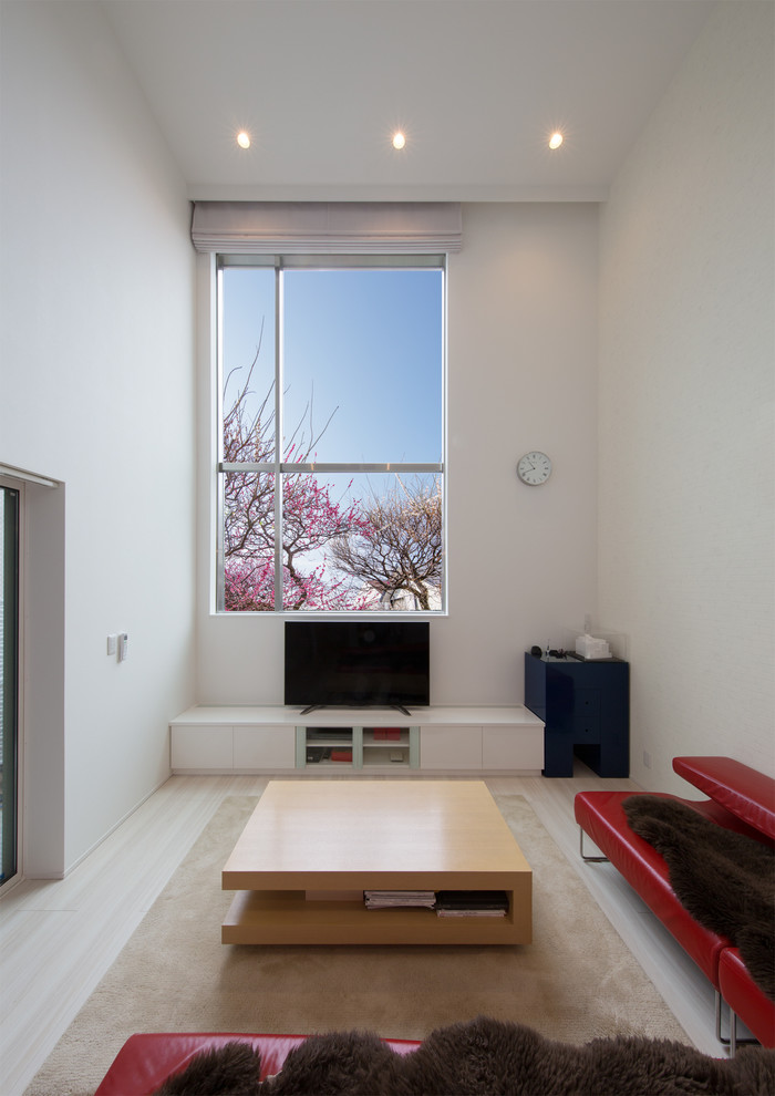 Photo of a contemporary family room in Tokyo with white walls, painted wood floors, a freestanding tv and beige floor.