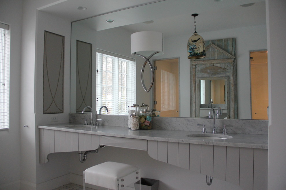 This is an example of a transitional master bathroom in Charlotte with marble benchtops.