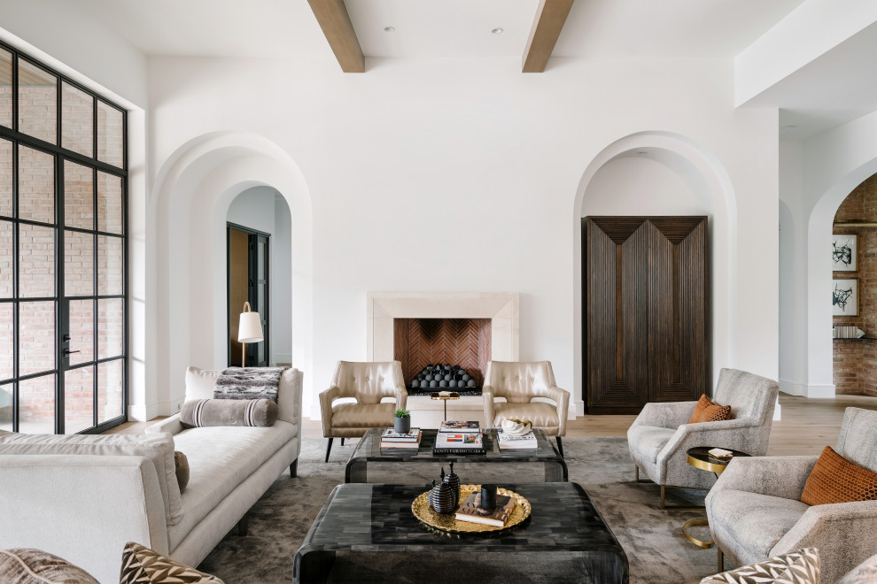 Expansive mediterranean formal living room in Austin with white walls, light hardwood floors, a standard fireplace and beige floor.