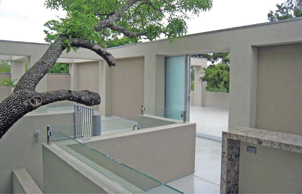 This is an example of a large modern backyard patio in Dallas with tile.