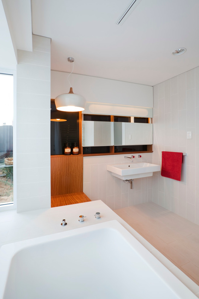 Contemporary bathroom in Perth with furniture-like cabinets, a corner tub, white tile, porcelain tile and a wall-mount sink.