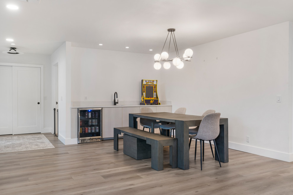Ispirazione per una sala da pranzo aperta verso il soggiorno moderna di medie dimensioni con pareti bianche, pavimento in vinile e pavimento marrone