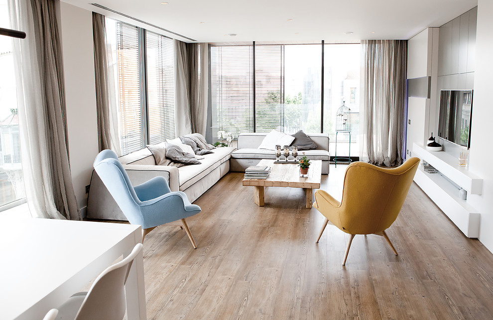 Foto de salón para visitas abierto contemporáneo de tamaño medio sin chimenea con paredes blancas, suelo de madera en tonos medios y televisor colgado en la pared