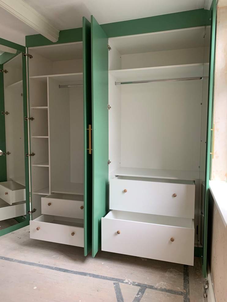 Réalisation d'une armoire encastrée design de taille moyenne avec un placard à porte plane, des portes de placards vertess et un sol en bois brun.