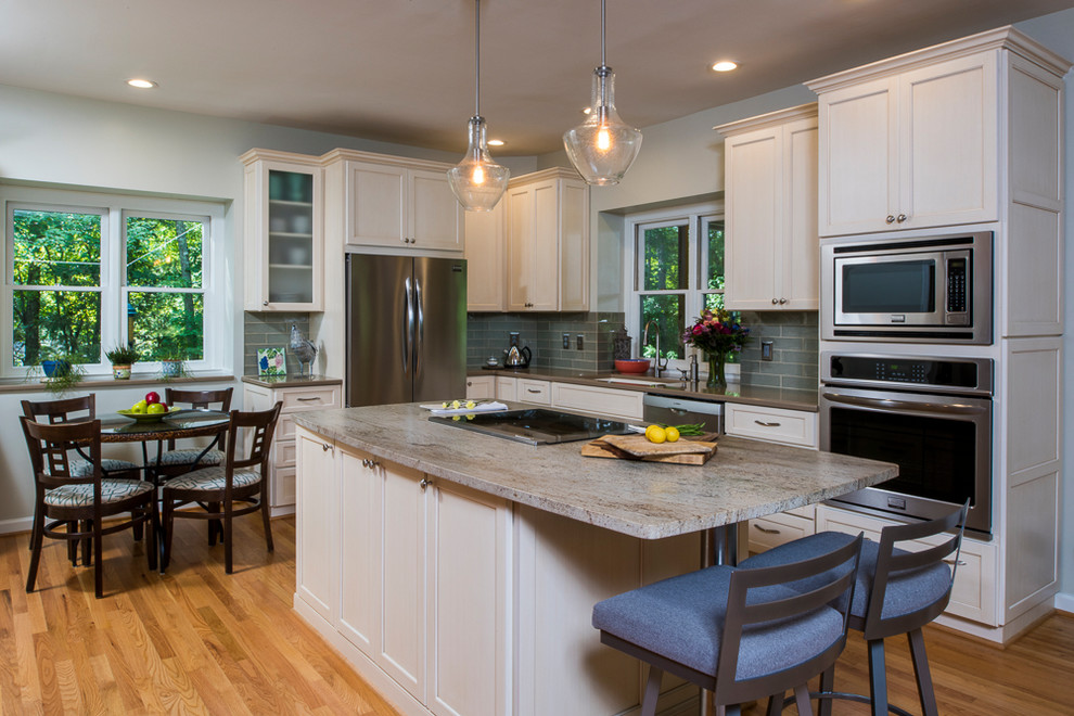 Transitional l-shaped light wood floor eat-in kitchen photo in Raleigh with an undermount sink, shaker cabinets, blue backsplash, stainless steel appliances and an island