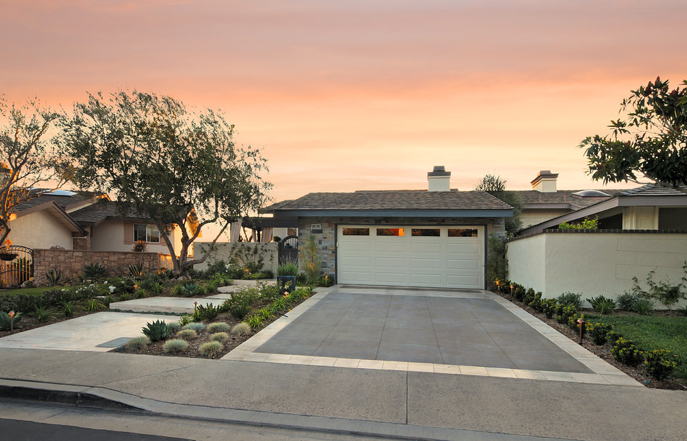 Photo of a mid-sized contemporary front yard full sun driveway in Orange County with a garden path and natural stone pavers.