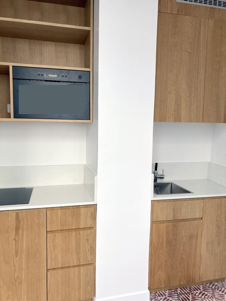 Imagen de cocina lineal contemporánea abierta con encimera de cuarcita, encimeras grises y puertas de armario de madera oscura
