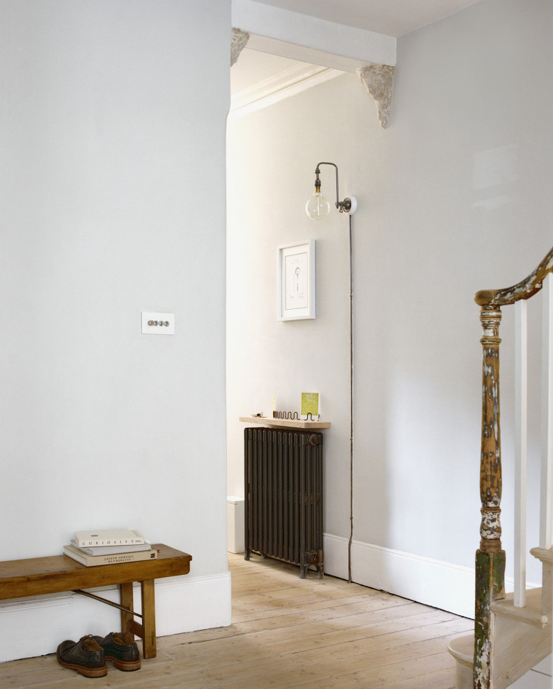 Idee per un piccolo ingresso o corridoio minimal con pareti grigie, parquet chiaro e pavimento beige