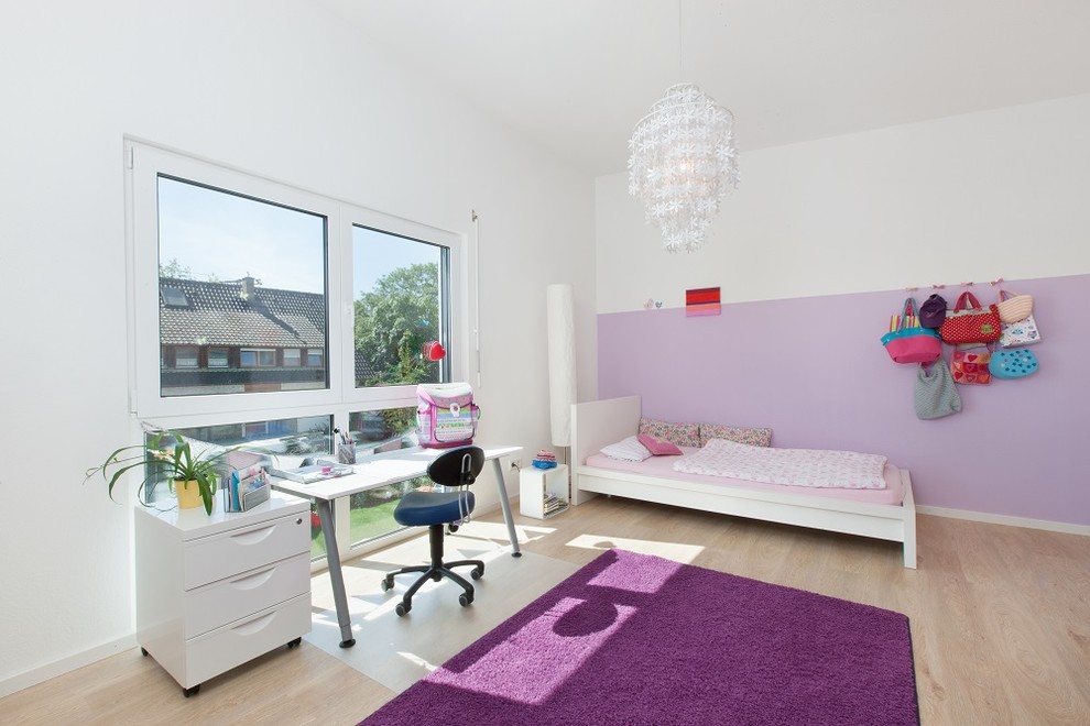 Design ideas for a mid-sized contemporary kids' bedroom for kids 4-10 years old and girls in Stuttgart with purple walls, light hardwood floors and brown floor.