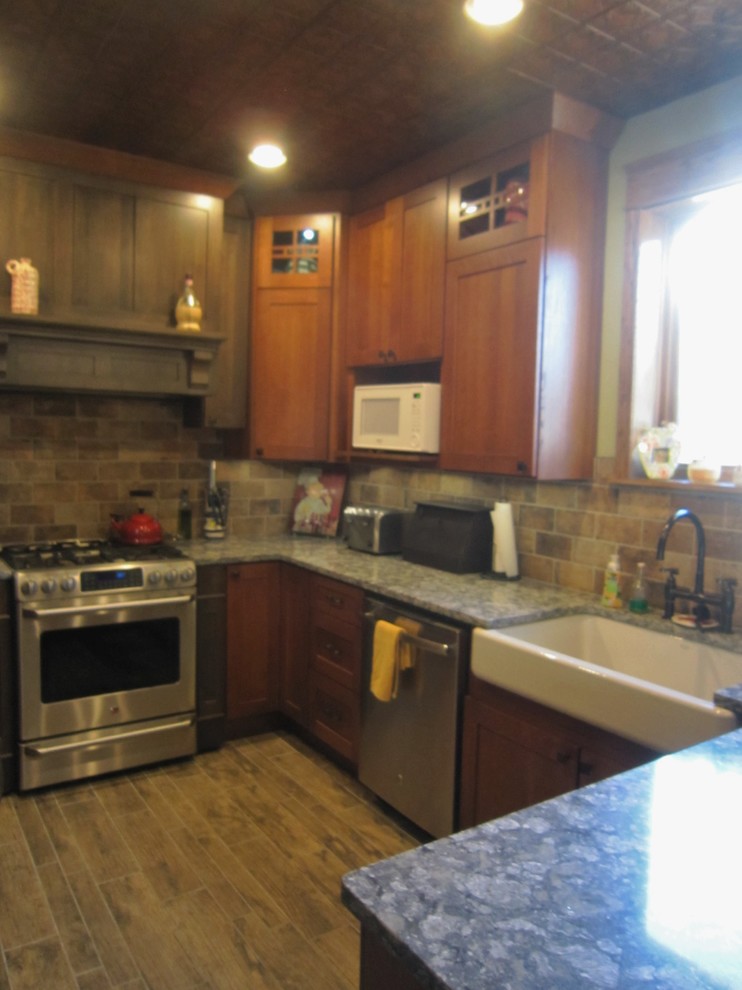 Eat-in kitchen - rustic u-shaped porcelain tile eat-in kitchen idea in Chicago with a farmhouse sink, shaker cabinets, porcelain backsplash, stainless steel appliances, a peninsula, dark wood cabinets, quartz countertops and brown backsplash