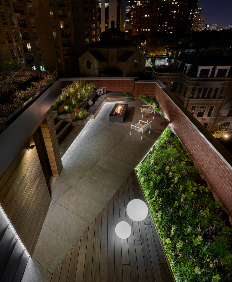 Inspiration for an expansive contemporary rooftop deck in Chicago with a fire feature and a pergola.