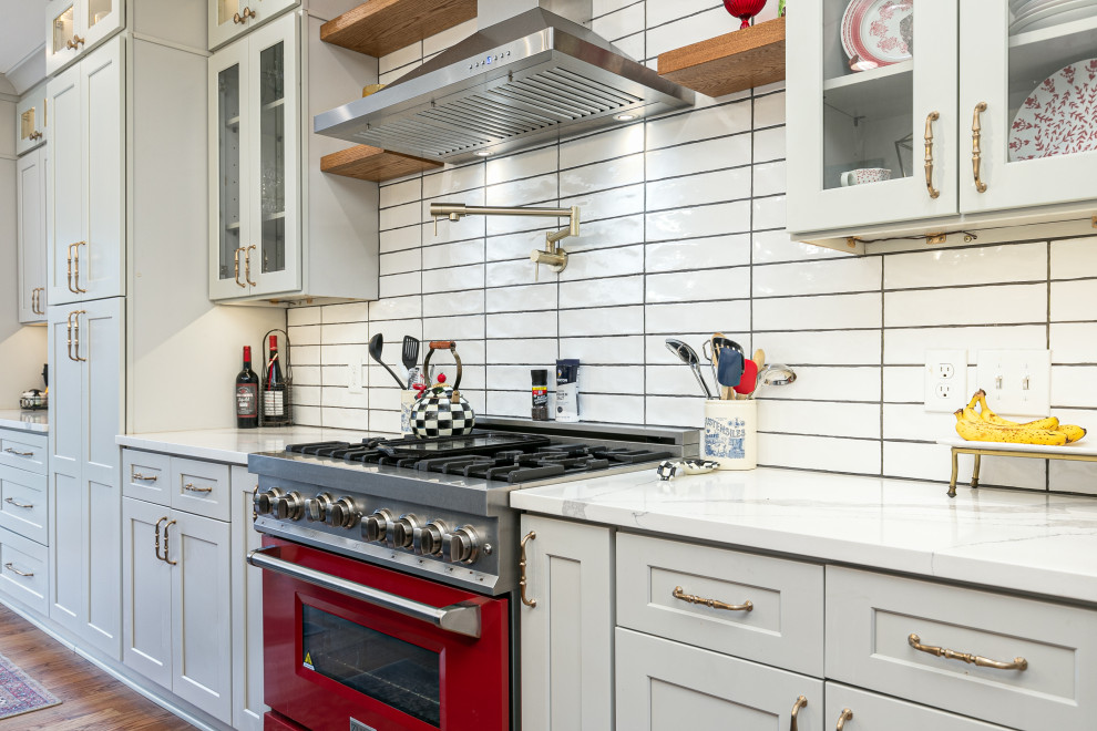 Bild på ett funkis kök, med skåp i shakerstil, vita skåp, bänkskiva i kvartsit, vitt stänkskydd, stänkskydd i tunnelbanekakel och rostfria vitvaror