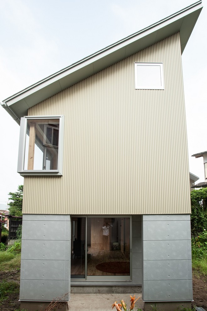 Inspiration for a modern two-storey beige exterior in Other with metal siding and a shed roof.
