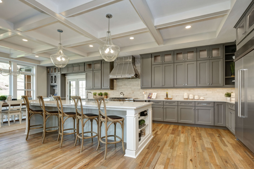 Inspiration for a large traditional l-shaped eat-in kitchen in Other with an undermount sink, shaker cabinets, grey cabinets, beige splashback, stainless steel appliances, medium hardwood floors, with island, beige floor and white benchtop.