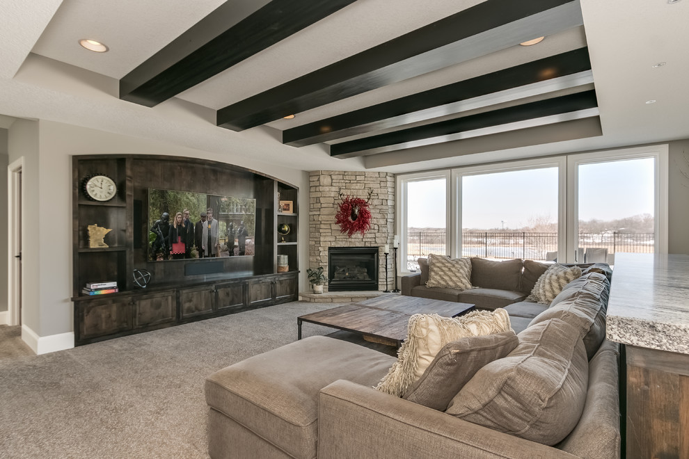 Photo of a country open concept family room in Minneapolis with a game room, grey walls, carpet, a corner fireplace, a stone fireplace surround, a built-in media wall and beige floor.