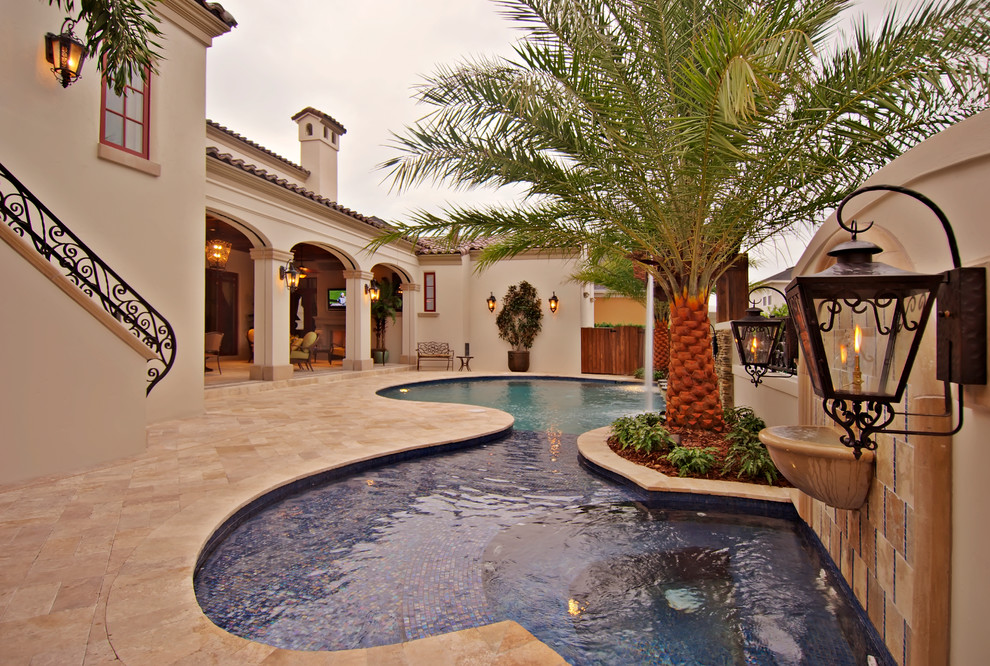 Mid-sized mediterranean backyard custom-shaped pool in Orlando with tile and a hot tub.
