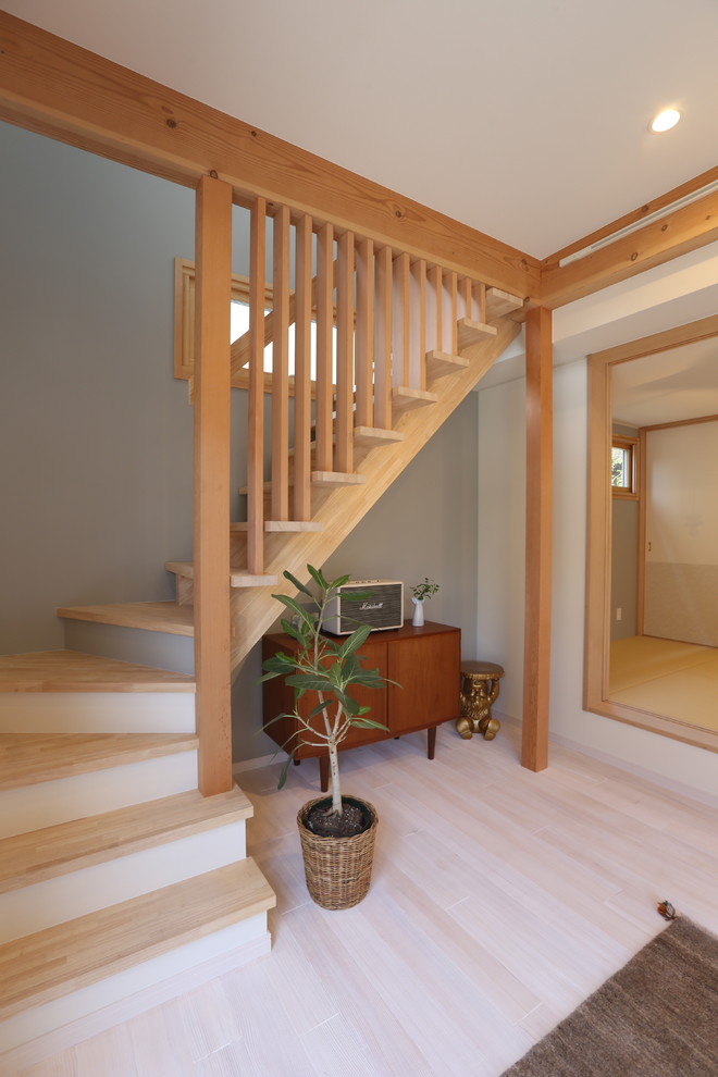 Inspiration for a scandinavian wood staircase in Other with open risers and wood railing.