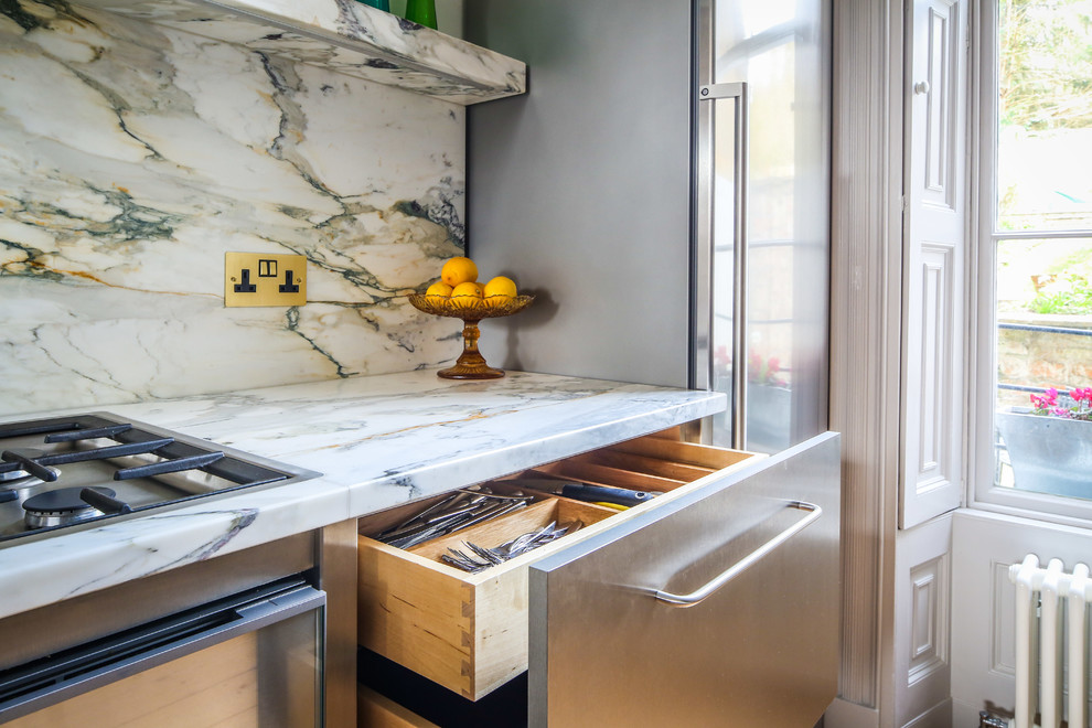Photo of a mid-sized contemporary l-shaped eat-in kitchen in Other with an undermount sink, flat-panel cabinets, stainless steel cabinets, marble benchtops, multi-coloured splashback, marble splashback, stainless steel appliances, light hardwood floors, no island and yellow floor.