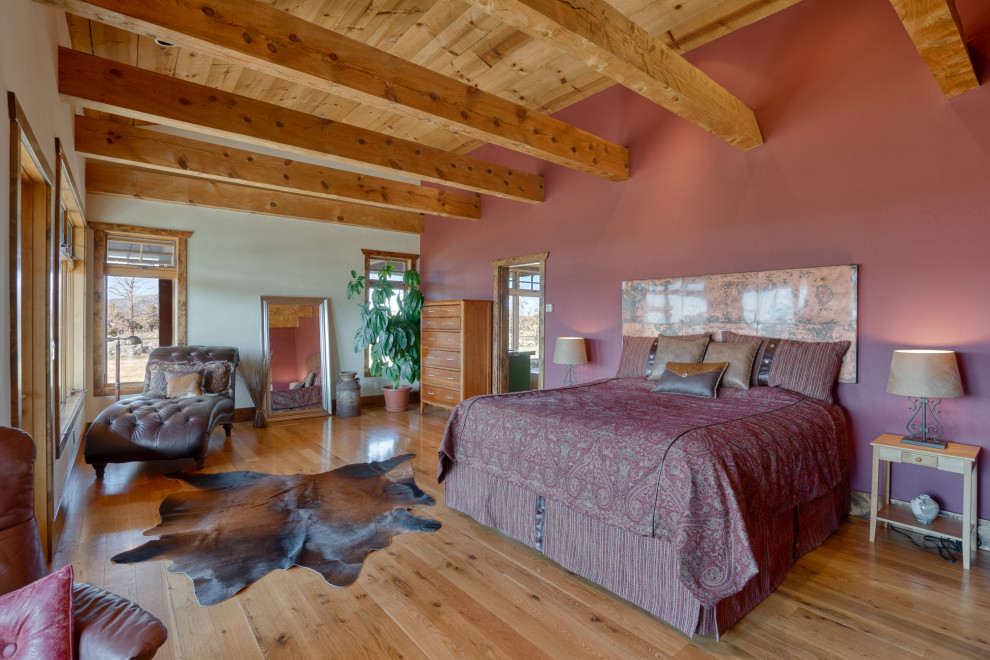 Großes Country Hauptschlafzimmer mit roter Wandfarbe, braunem Boden und freigelegten Dachbalken in Sonstige