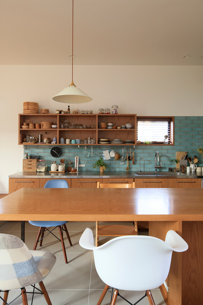 Источник вдохновения для домашнего уюта: параллельная кухня в стиле рустика с плоскими фасадами, коричневыми фасадами, синим фартуком, островом и серым полом