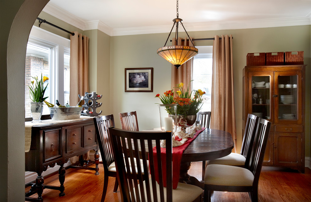 Photo of a mid-sized arts and crafts separate dining room in Chicago with green walls and medium hardwood floors.