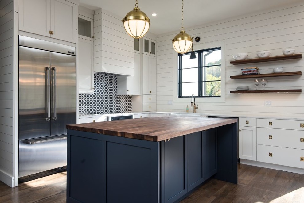 Inspiration for a mid-sized country l-shaped kitchen in Other with a farmhouse sink, white cabinets, stainless steel appliances, with island, brown floor, shaker cabinets, wood benchtops, multi-coloured splashback and dark hardwood floors.