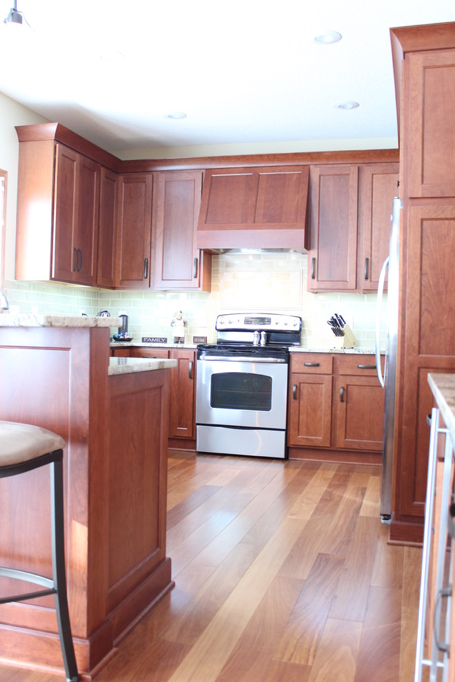 Photo of a mid-sized traditional u-shaped kitchen pantry in Other with flat-panel cabinets, brown cabinets, stainless steel appliances and a peninsula.