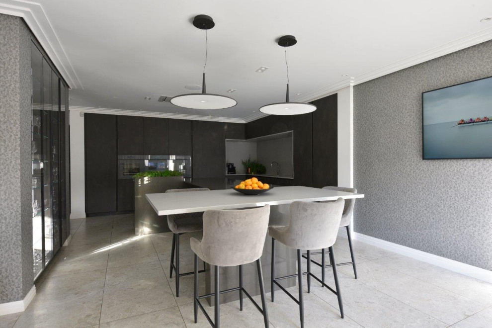 Inspiration for a large contemporary grey and cream l-shaped open plan kitchen in Manchester with a submerged sink, flat-panel cabinets, grey cabinets, quartz worktops, beige splashback, limestone splashback, coloured appliances, porcelain flooring, an island, grey floors, grey worktops, a coffered ceiling and feature lighting.