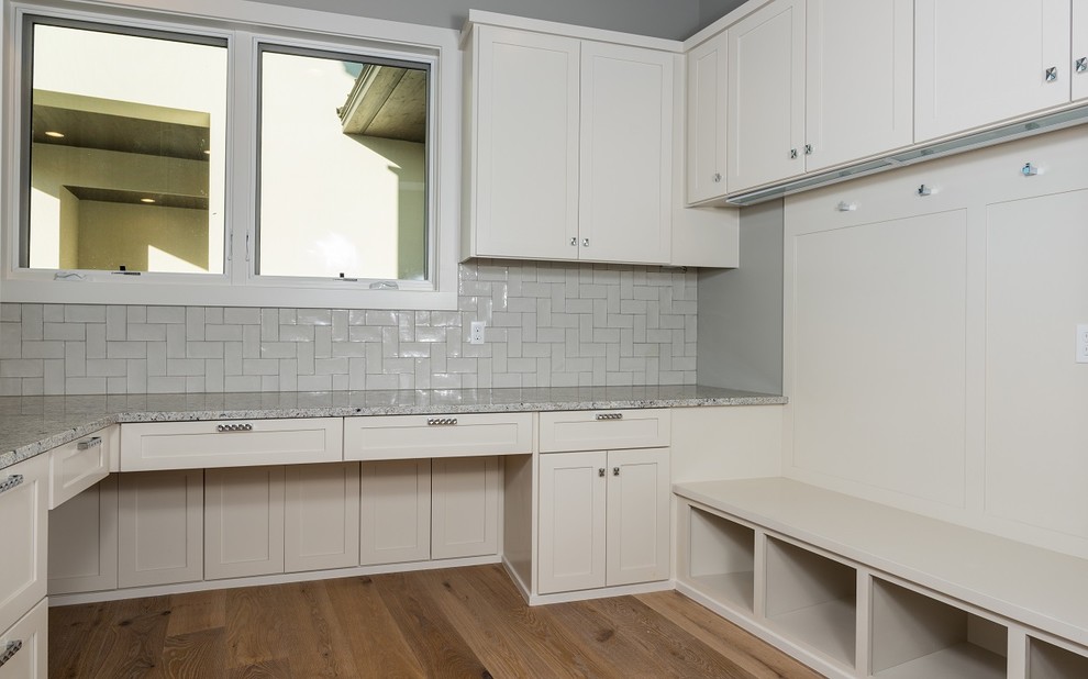 This is an example of a mid-sized contemporary galley utility room in Austin with shaker cabinets, white cabinets, grey walls, light hardwood floors and granite benchtops.