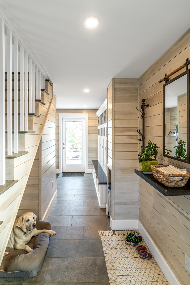 Inspiration for a beach style mudroom in Portland Maine with beige walls, a single front door, a glass front door, grey floor and wood walls.